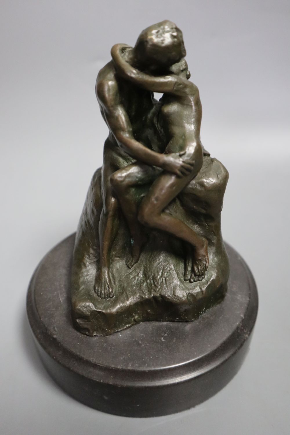 A cast metal sculpture Kiss after Rodin, height 14cm and another of Arabs